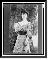 Historic Framed Print, [Alice Roosevelt Longworth, three-quarter length portrait, standing in front of tree, facing slightly left, holding small dog],  17-7/8" x 21-7/8"