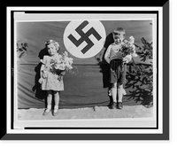 A boy and a girl, each holding flowers and standing on either side of a swastika, in Muhldorf am Inn, Germany Classic, Antique Poster
