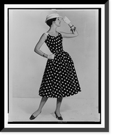 A fashion model posed in a polka dot sun dress and straw hat Classic, Historic Reproduction