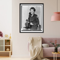 Historic Framed Print, [Toni Frissell, half-length portrait, seated, facing slightly left, in Red Cross uniform, holding camera],  17-7/8" x 21-7/8"