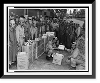 Private Sam Oka hands over to Private Henry Oshiro his share of the generous gifts of candies and cigarettes sent to members of the Japanese-American Combat Team by a Hawaiian pineapple company Her