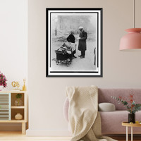 A British woman with a few of her belongings in a baby carriage is stopped by an Air Raids Precautions worker on a London street destroyed by German bombs during World War II Classic Wall Art Pri