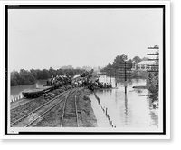 Workers unloading sandbags from flatbed railroad car, while others are building a levee, partially submerged electric power line poles on right.Ewing, Inc., Baton Rouge. Classic, Historic Print