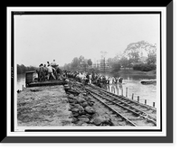 Workers unloading sandbags from flatbed railroad car, while others are building a levee, partially submerged electric power line poles on right.Ewing, Inc., Baton Rouge. - 2 Vintage Wall Art Prin