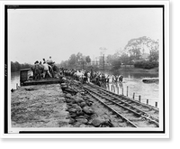 Workers unloading sandbags from flatbed railroad car, while others are building a levee, partially submerged electric power line poles on right.Ewing, Inc., Baton Rouge. - 2 Vintage Wall Art Prin