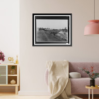 Chickens and cows grazing on side of levee, floodwaters in background and lower ground with buildings with minor damage, shack on crest, tents in background.Ewing, Inc, Vintage Print