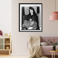 Martha Argerich, full-length portrait, facing front, seated, holding luggage, at Pier 86, after having arrived on the liner Constitution.World Telegram & Sun photo by Dick DeMarsico. Antique Wall