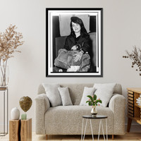 Martha Argerich, full-length portrait, facing front, seated, holding luggage, at Pier 86, after having arrived on the liner Constitution.World Telegram & Sun photo by Dick DeMarsico. Antique Wall