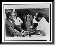 Liberian president William R. Tolbert and Henry Kissinger clasp hands across a table as others look on Classic, Historic Print