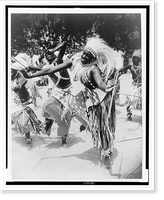 Dancer Butera, in traditional dress, and others, dance before gathering in background, possibly in Belgian Congo, Antique Poster