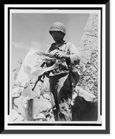 American soldier holding tattered Japanese flag, standing among rubble, probably in the Marshall Islands, Vintage Wall Art