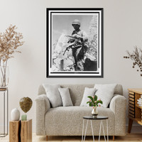 American soldier holding tattered Japanese flag, standing among rubble, probably in the Marshall Islands, Vintage Wall Art
