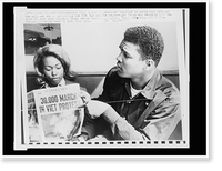 Historic Framed Print, Cassius Clay points to newspaper headline to prove that he's not the only one protesting the Viet Nam war,  17-7/8" x 21-7/8"