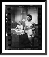 Historic Framed Print, [Woman model, standing in an office, smoking while modeling undergarments],  17-7/8" x 21-7/8"
