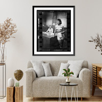 Historic Framed Print, [Woman model, standing in an office, smoking while modeling undergarments],  17-7/8" x 21-7/8"
