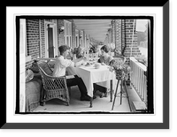 Man and woman eating at table on front porch of row house, Antique Poster