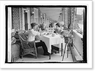 Man and woman eating at table on front porch of row house, Antique Poster