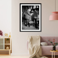 Historic Framed Print, Man leaning on chair looking at photo,  17-7/8" x 21-7/8"