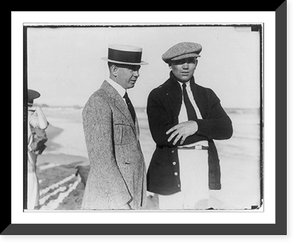 Jack Dempsey at his training camp, June 1921: standing on beach with man; wearing visored cap, Antique Print