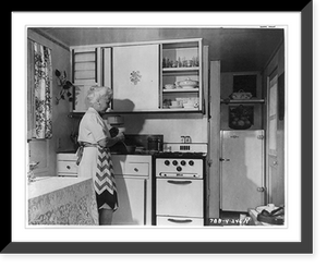 Kitchen of Goodyear Wingfoot prefabricated home with housewife preparing meal, Historic Print
