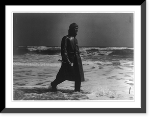 Historic Framed Print, 10 years at the same stand is the record of this all-Negro U.S. life saving unit. A watchman of the sea, this surf-man of the Pea Island Station patrols the beach on the lookout for a craft in distress,  17-7/8" x 21-7/8"