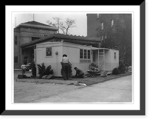 Wingfoot prefabricated home model erected in front of Goodyear Rubber Co., Washington, D.C., with three men planting shrubbery and flowers, Historic Reproduction