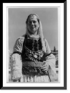 Albanian woman in elaborate dress, half-length, standing, facing left, Vintage Poster
