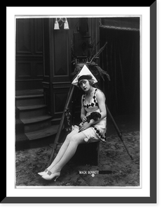Marvel Rea of Mack Sennett comedy films seated, in front of motion picture camera, full-length portrait, holding puppy, Vintage Poster