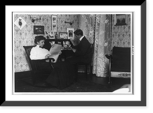 Historic Framed Print, [Mr. and Mrs. Jack Stowell in their parlor, sitting at desk, Washington, D.C.],  17-7/8" x 21-7/8"