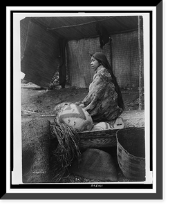 A Skokomish Indian chief's daughter, half-length portrait, seated on canoe, facing left, Vintage Poster