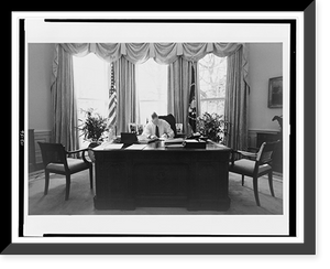 Historic Framed Print, [Bill Clinton, half-length portrait, seated at desk in the Oval Office, facing front, writing],  17-7/8" x 21-7/8"