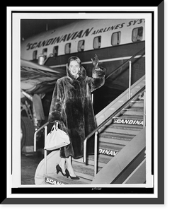 Christine Jorgensen, full-length portrait, facing front, waving as she boards an airplane, at Copenhagen, Denmark, Historic Print