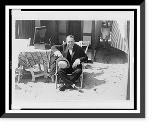 William R. Hearst, Sr., full-length portrait, seated by phonograph, on beach, facing front in Lido, Italy Classic, Antique Print