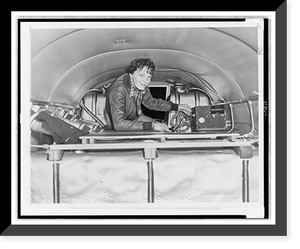 Amelia Earhart, seated in airplane, checking equipment, Antique Print