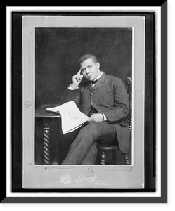 Historic Framed Print, [Booker T. Washington, three-quarter length portrait, seated, facing slightly left, holding newspaper],  17-7/8" x 21-7/8"