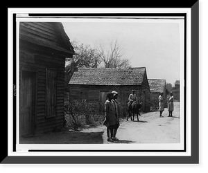 Two African American women and three children, one of them on a cow, on an unpaved road, in front of buildings, Vintage Poster
