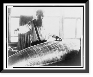Konstantin Tsiolkovsky, half-length portrait, facing front, looking down at model of an early Russian rocket, Historic Print