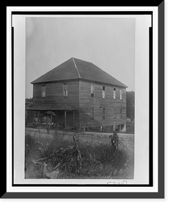 Exterior view of large unidentified building in Georgia, with a man standing in front holding an umbrella, and a group of children sitting on the porch, Antique Poster