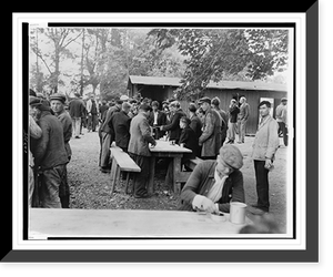 French men, refugees from the Allied battles in Normandy, gather at an Allied assembly center for meals, eaten outside at wooden tables.Acme photo by Andrew Lopez for the War Picture pool. Herita