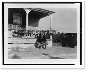 Historic Photo Print - Man squatting with rifle across lap