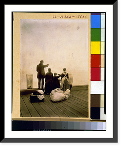 Four immigrants and their belongings, on a dock, looking out over the water; view from behind - 2, Historic Print