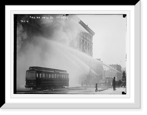 Historic Framed Print, Firemen spraying burning building on 14th St., trolley in foreground, New York,  17-7/8" x 21-7/8"