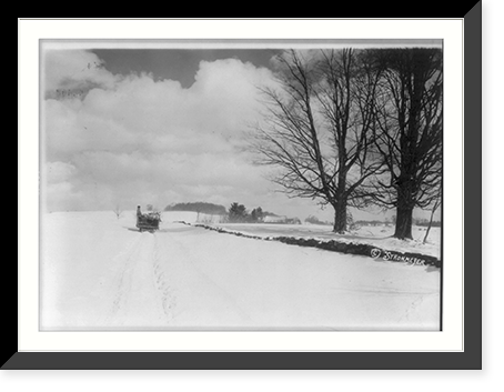 Looking down snow-covered road in New England; horse-drawn sled in background, Historic Reproduction