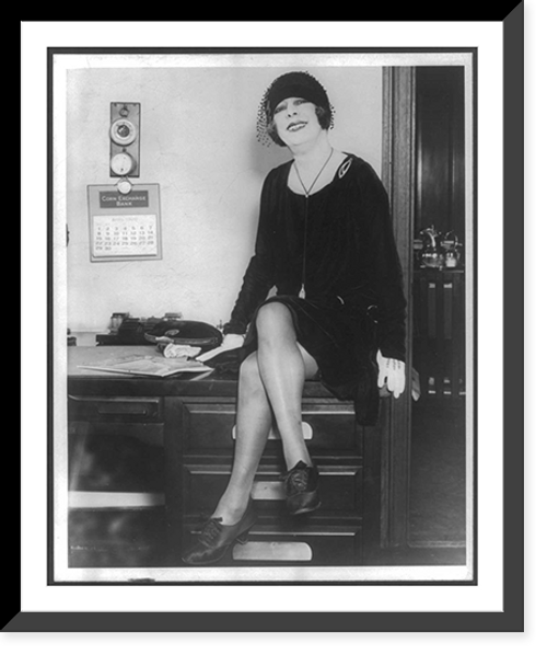 Historic Framed Print, [Beatrice Houdini, full-length portrait, facing front, seated on desk],  17-7/8" x 21-7/8"