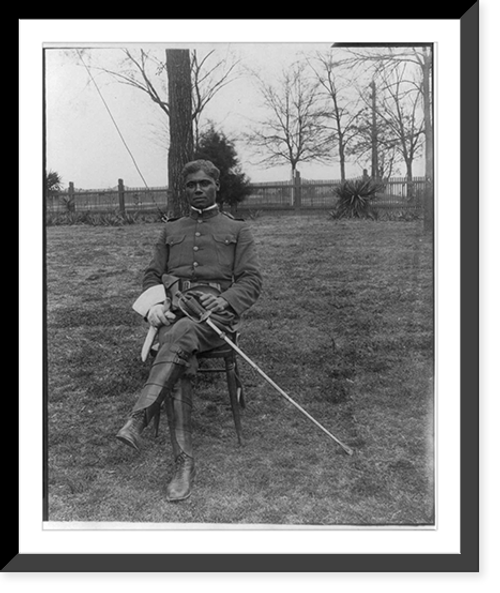 Historic Framed Print, [25th anniversary of Tuskegee Inst., Ala., 1906: Young man in uniform seated on lawn],  17-7/8" x 21-7/8"