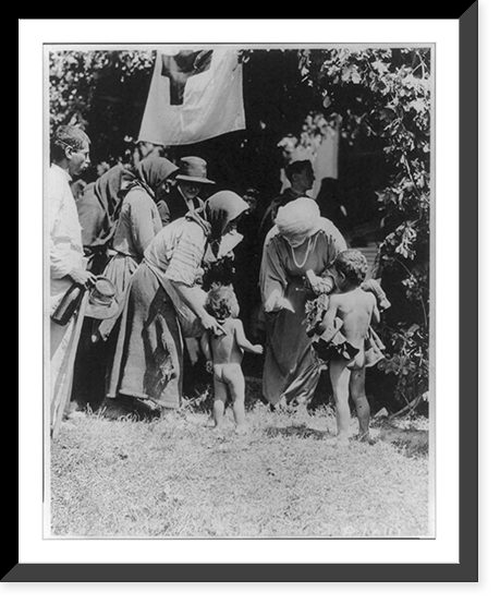 2 American Red Cross women, Rachel Tombuce and ____ Marie, distributing clothing to two small naked children. Mountain village in the north of Roumania. Red Cross flag hanging in bg. Vintage Wall