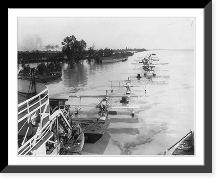 Paddle wheel steamer towing several seaplanes; two barges and partially submerged trees in background.Ewing, Inc., Baton Rouge, Historic Reproduction