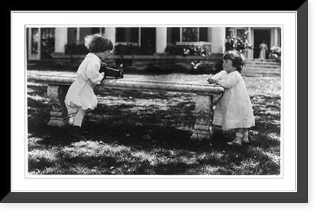 One child aiming camera, on bench, at another child, Washington, D.C. Classic, Vintage Poster