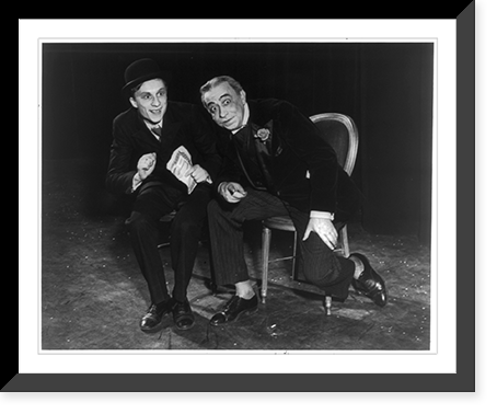 2 actors seated on chairs on stage, one is leaning forward with arm on leg and pointing, Historic Print