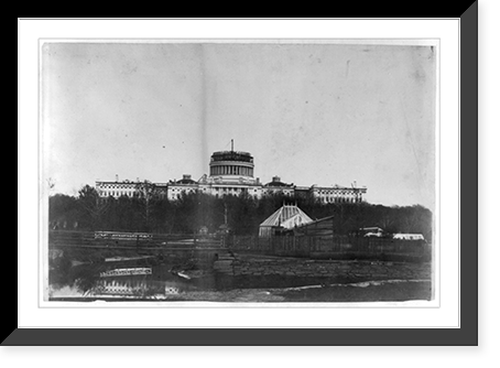 Historic Framed Print, [West front of the United States Capitol, with the new cast-iron dome under construction. In the foregrd. is the Tiber Creek or Washington City Canal and the octagonal greenhouse for the Botanic Garden],  17-7/8" x 21-7/8"